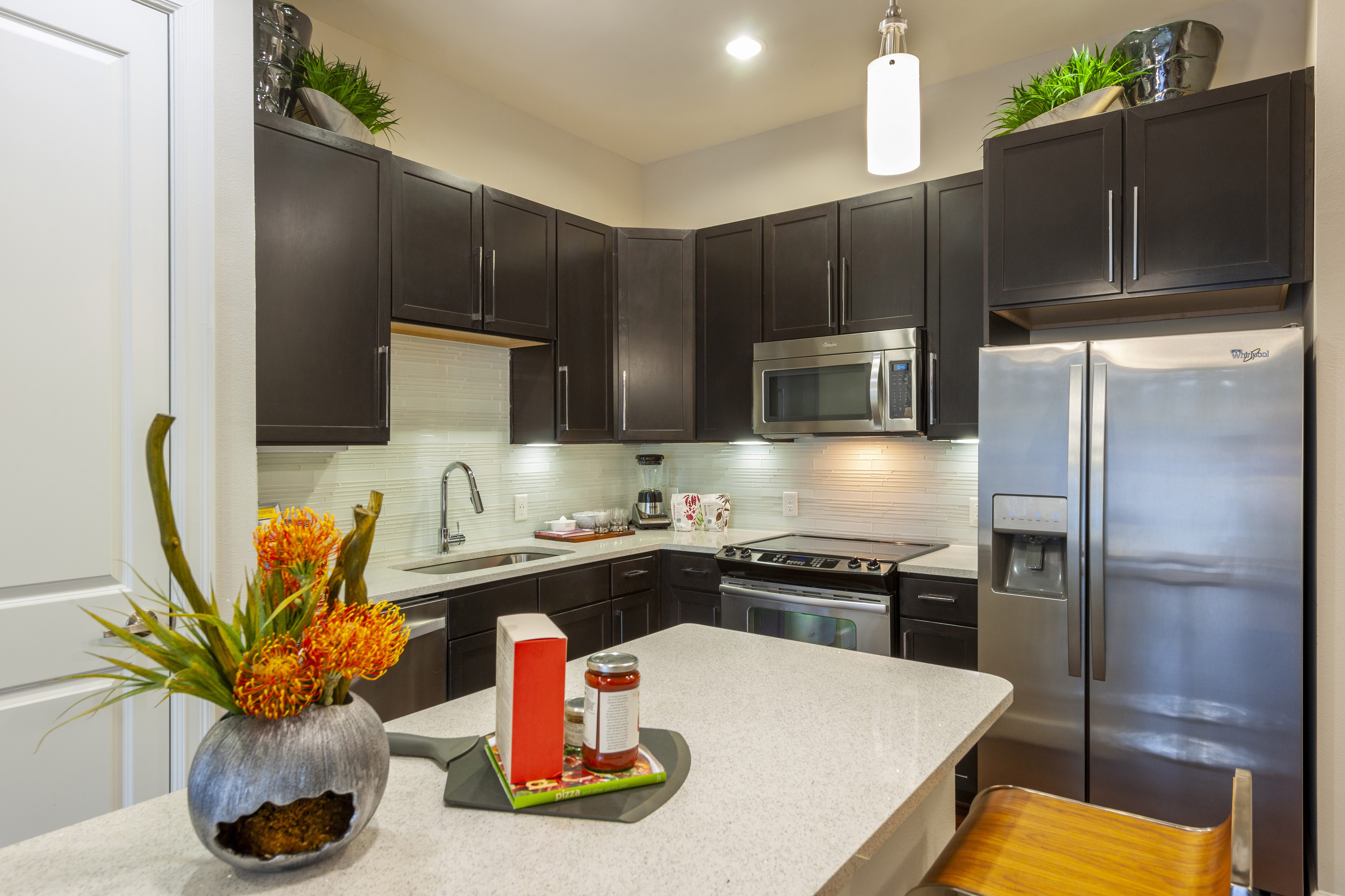 A modern kitchen with dark cabinets at the Ascent at CityCentre Apartments in Houston, Texas.